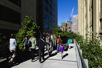 USA, New York, Manhattan, people walking on the Falcone Flyover on the High Line linear park between buildings on a disused elevated railroad spur of the West Side Line. USA, New York State, New York...