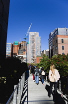 USA, New York, Manhattan, people walking on the Falcone Flyover on the High Line linear park between buildings on a disused elevated railroad spur of the West Side Line. USA, New York State, New York...